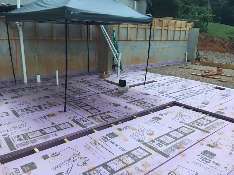 Cutting the foam insulation board to fit around the plumbing and grade beam trenches