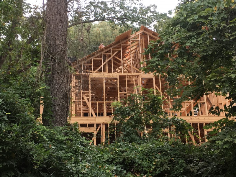 A view from the road. You can see Reid on the roof, working to place the decking on the trusses.