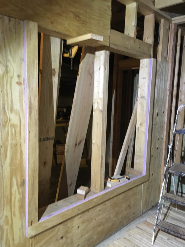 A view of the border we installed around each window, putting the plywood outside of the foam to provide a hard material to screw the windows into.