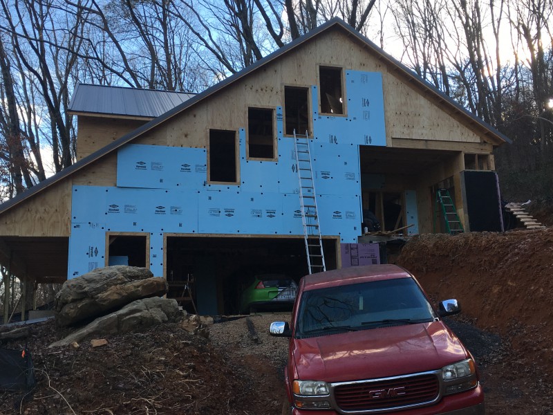 A view of the north side of the house with the plywood layer complete and the foam layer partially finished.