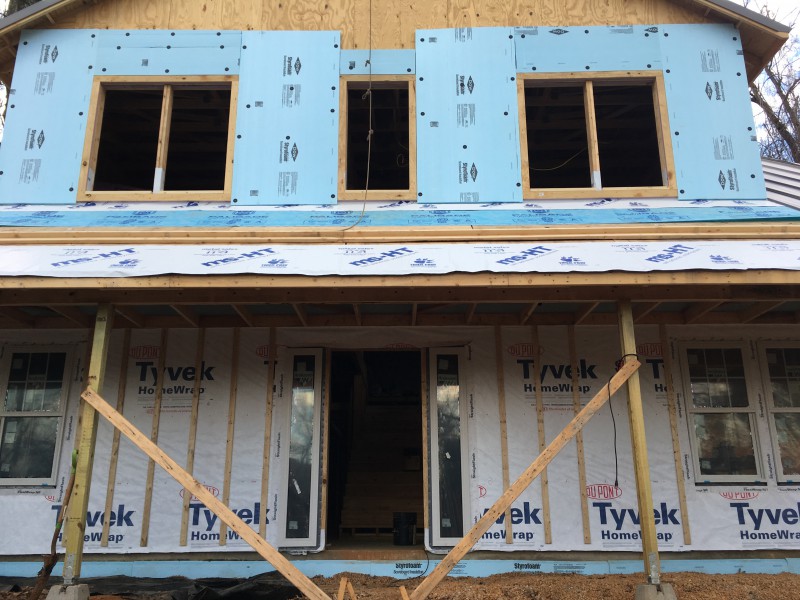 The front of our house, in all stages of completion: plywood only, foam layer, Tyvek with slats, and windows installed.