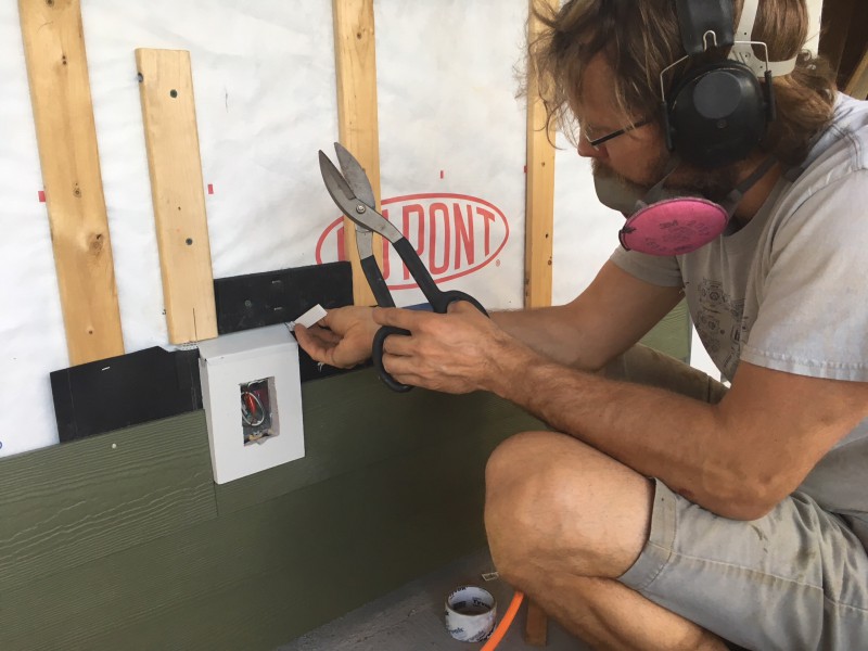 John working on the trim for an exterior outlet. This small penetration required a piece of fiber cement with a square hole (had to be cut by hand), cor-a-vent strips above and below, creatively placed furring strips, and a piece of flashing on top of the trim.