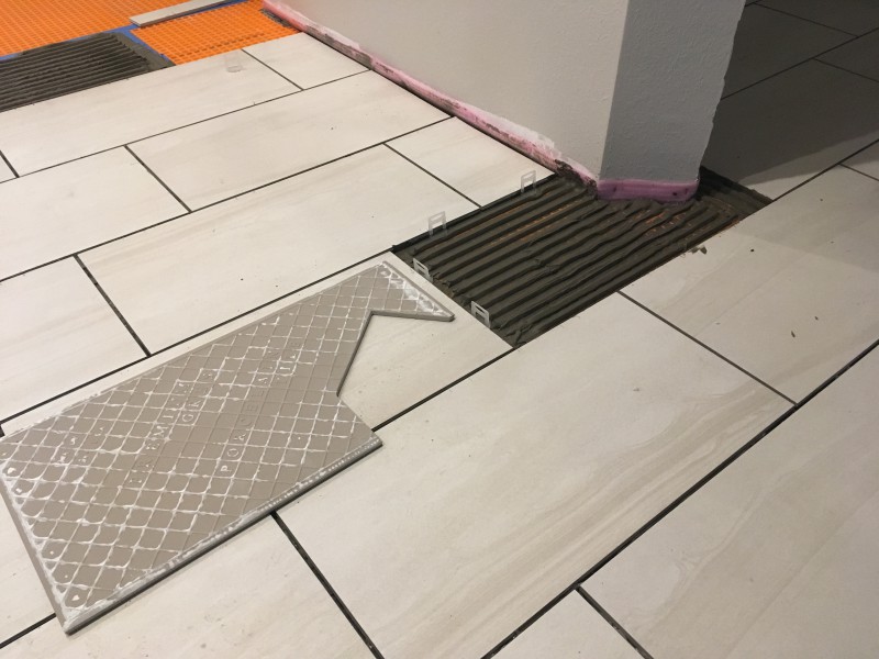 A complicated piece that had to be cut with the Makita grinder. You can also see the combed mortar and leveling clips that are put in before laying that tile.